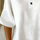 Top met wafelpatroon en knopendetail voor een ontspannen look